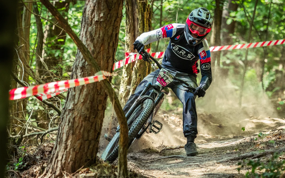Pretekár v skalnatej pasáži enduro trate ohraničenej páskami — Slovenský pohár v endure 12.–13. 9. 2026 na Donovaloch
